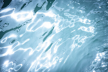 Blurred transparent blue colored clear calm water surface texture with splashes and...