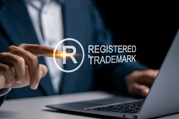 Copyright protection concept. Registration or registration for trademark. Businessman using laptop with Register trademark and logo on virtual screen.