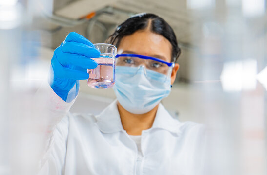 retrato de mujer en el laboratorio de química con pipetas y tubos de ensayo