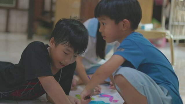 Adorable little kindergarten child boy and girl drawing color on paper in house