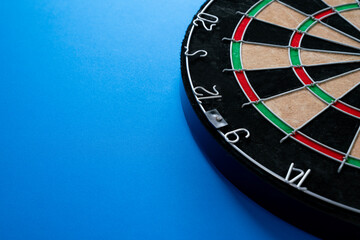 target dart board on the blue table background, center point, head to target marketing and business...