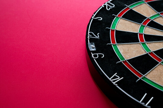 target dart board on the red table background, center point, head to target marketing and business success concept