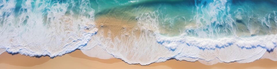 Aerial view of a paradise beach where the waves of the sea break on the shore. Top view of a sandy coast with turquoise blue water and white foam on sunny day. Summertime, marine, seashore banner. 
