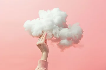 a womans hand is holding a cloud against pink background © Salander Studio