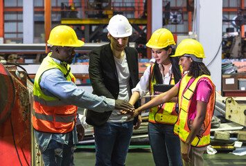 Group of diversity factory man and woman teammates putting hands together encouraging in manufacturing factory