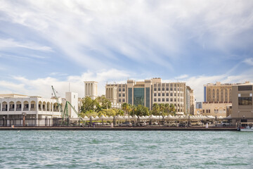 View from the tourist Arab boat abra on the embankment of Dubai Creek in Dubai city, United Arab Emirates