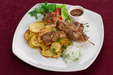 Delicious kebab with fried potatoes on a plate, menu for a restaurant