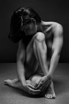 Naked woman Yoga on black background. Fine art photo of female body