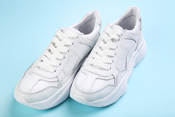 Pair of white shoes on blue background - 760324285