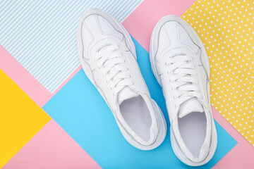 Pair of white shoes on colorful paper background