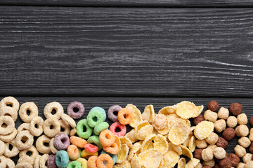 Various corn flakes on black wooden table