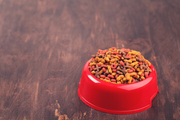 Dry pet food in bowl on brown wooden table - 760327286