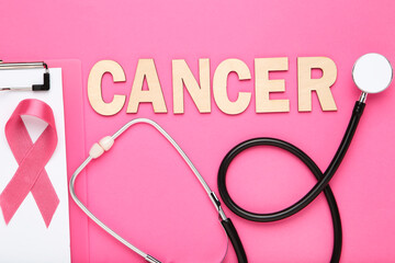 Ribbon with clipboard, stethoscope and word Cancer on pink background