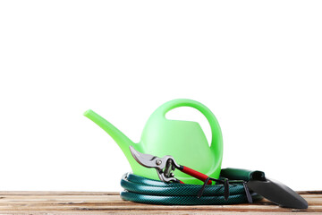Garden tools with watering can on wooden table