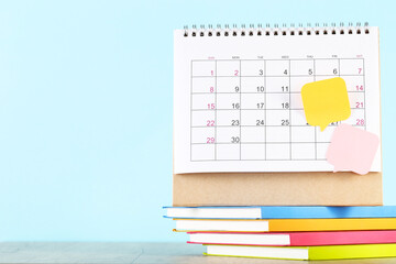 Calendar page with stack of notepads and speech bubbles on blue background - 760327872
