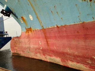 Ship with Anchor on large cargo ship's anchor being pulled. Blue and red ship, While docked at the...