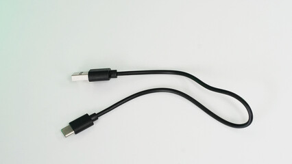 Black USB cable with plugs type A and type C at the edges on a white background