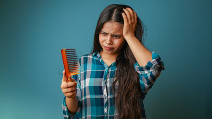 Woman with hair loss problem isolated over blue color background, hair fall concept, portrait of a...