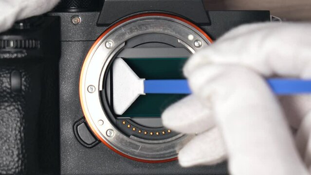 Removing sensor dust from a modern digital mirrorless  full frame camera sensor using a sensor swab – top view close up
