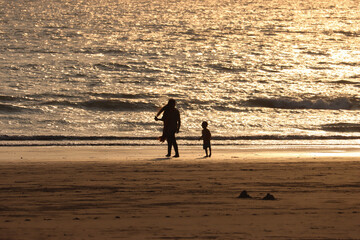 Fototapeta na wymiar parent and child walking on beach , silhouette photo 