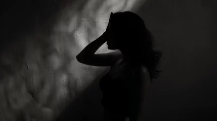 Poster Silhouette of a young woman in a dark room with shadows © Vladimir