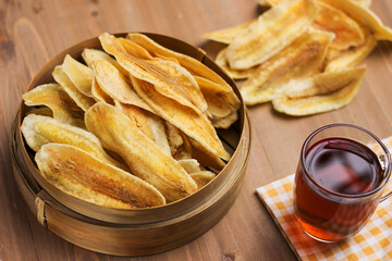 Crispy Banana chips or Keripik pisang in indonesia, served in bamboo bowl on the table