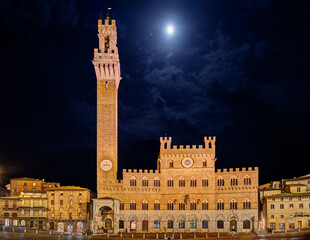 Obraz premium Siena, Tuscany, Italy: night view of the ancient town hall Palazzo Pubblico and the tower Torre del Mangia in the city square Piazza del Campo