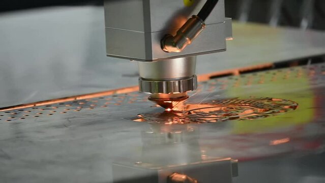Close up  scene the fiber laser cutting machine  cut the metal plate with the sparkling light.