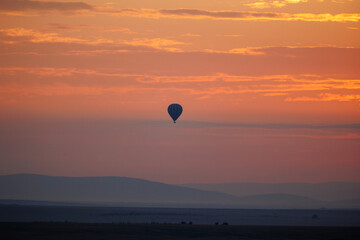 A beautiful landscape photo shot in Masai Mara Kenya, the photo also shows vast dramatic sky and balloon safari in the morning.