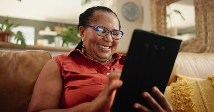 Tablet, search and senior black woman on a sofa with glasses for reading social media, meme or gif at home. Digital, app and old African person with online comic, show or Netflix and chill in house