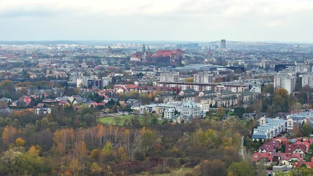 Panoramic View of Krakow Skyline in Autumn, Expansive view over the colorful autumn canopy of Krakow, highlighting the city's diverse architecture and distant hills.