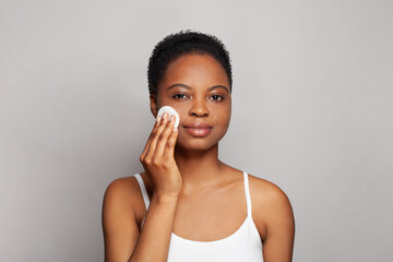 Attractive healthy woman with fresh skin holding white cotton pad in her hand. Medicine, treatment and skin cleansing concept