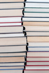 Two stacks of hardcover books of different thicknesses, new and old with curved border between