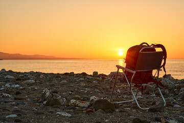 amanecer en la playa con una silla y una mochila