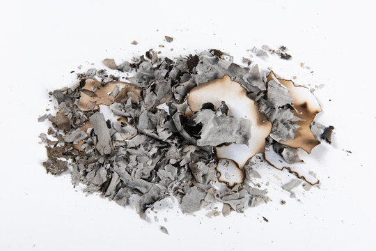 pile of burnt paper ashes on white background. 