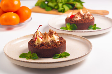 Delicious chocolate tart garnish with cherry and mint. Classic dessert. - obrazy, fototapety, plakaty