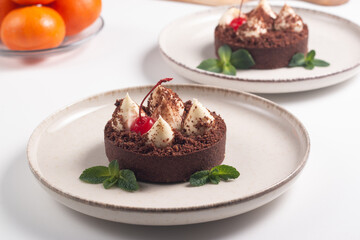 Delicious chocolate tart garnish with cherry and mint. Classic dessert. - 760444635