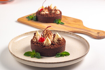 Delicious chocolate tart garnish with cherry and mint. Classic dessert. - 760444662