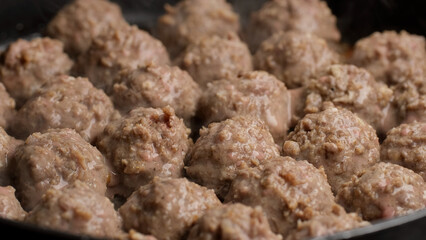 Frying meatballs in pan, close up