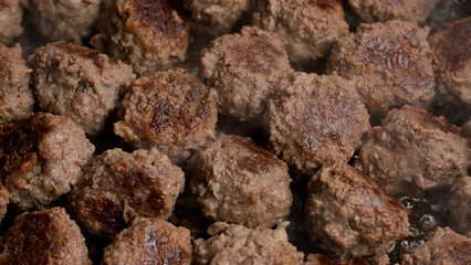 Frying meatballs in pan, close up