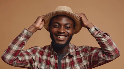 Happy black guy in casual summer outfit, straw hat on yellow studio background. Positive African American man enjoying summertime, having fun