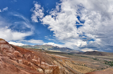 brown and red mountains under fine large clouds - 760447088