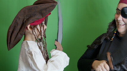 Pirate game. Mom and son having fight with fake cutlasses. Halloween activity. High quality photo