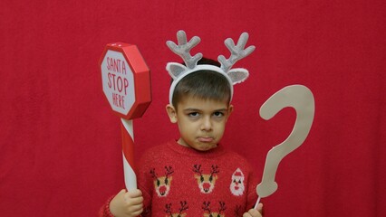 Sad child naughty boy questioning if Santa Claus will come this Christmas. High quality photo