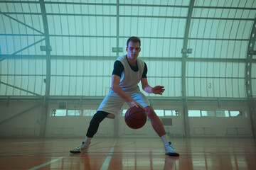 Professional basketball player training in an empty basketball stadium.