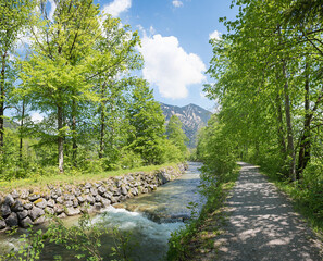 idyllic walkway under trees, along Rottach river, spring landscape upper bavaria