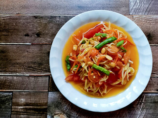 Thai food recipes: Papaya salad spicy (Som tam) on wooden background,