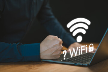 While using a laptop, a man faces difficulties connecting to WiFi, encountering either connection issues or incorrect password, leading to a delay in loading digital data from websites. - 760471687
