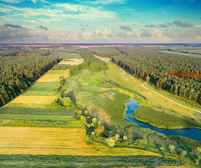 Beautiful summer landscape. Top view of a stream in a meadow among forests and farmlands - 760473821