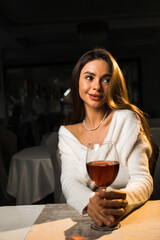 Young woman holding a glass of wine.Woman drinking wine in a restaurant.Red wine concept